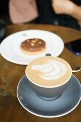 a cup of late coffee with flower shape design on top at cafe 