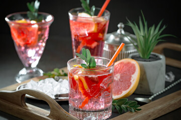 Fruit cocktail, in a glass with natural healthy fruits on a table with kitchen accessories.