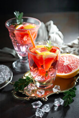 Fruit cocktail, in a glass with natural healthy fruits on a table with kitchen accessories.