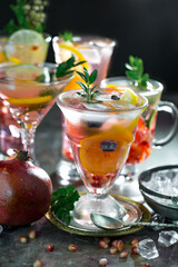 Fruit cocktail, in a glass with natural healthy fruits on a table with kitchen accessories.
