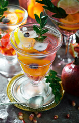 Fruit cocktail, in a glass with natural healthy fruits on a table with kitchen accessories.
