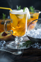 Fruit cocktail, in a glass with natural healthy fruits on a table with kitchen accessories.
