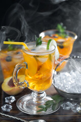 Fruit cocktail, in a glass with natural healthy fruits on a table with kitchen accessories.