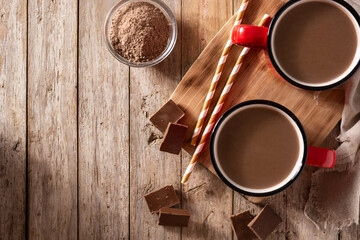 Traditional Mexican chocolate atole drink on wooden table. Top view. Copy space