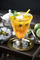 Fruit cocktail, in a glass with natural healthy fruits on a table with kitchen accessories.