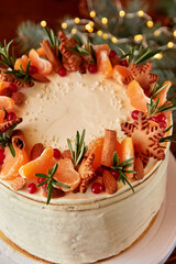 Festive Christmas cake decorated with fruits and rosemary.
