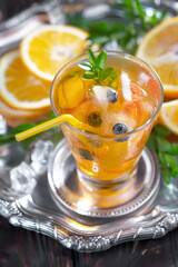 Fruit cocktail, in a glass with natural healthy fruits on a table with kitchen accessories.