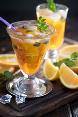 Fruit cocktail, in a glass with natural healthy fruits on a table with kitchen accessories.