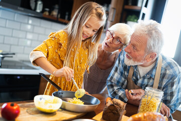 Smiling grandparents having breakfast with their granddaughter