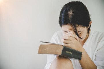Teen girl hand with Bible praying.