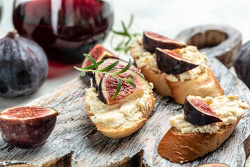 Canape or crostini with toasted baguette, Fresh figs, cream cheese and red wine. Delicious appetizer, ideal aperitif. top view