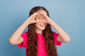Portrait of romantic charming girl demonstrate love heart gesture symbol on blue background