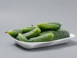 agricultural products green prickly cucumber on gray background