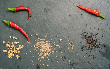 Spices and Chilli Peppers on Black Slate Tile