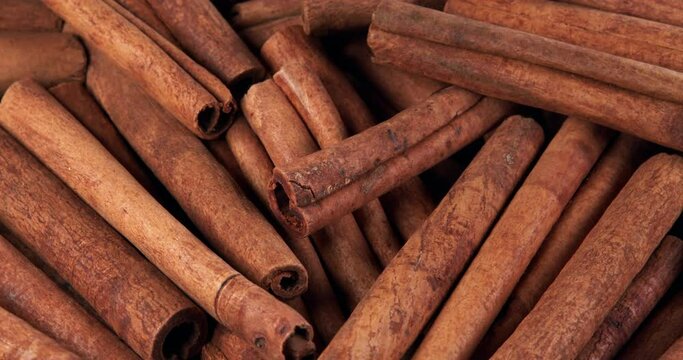 Cinnamon sticks rotate as a background. Fragrant cinnamon close-up. Spices with cinnamon. Food cooking video concept.