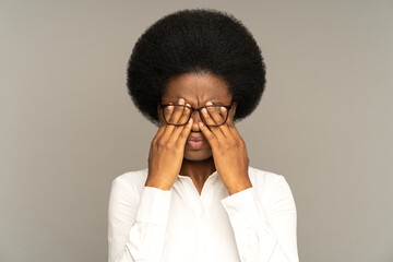 Sleepy young african business woman taking off glasses rubbing eyes feels tired after work on...