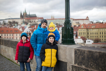 Happy family with children on a Charles bridge wintertime in Prague, Czech