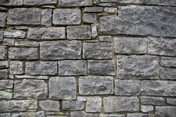Textured stone wall background. Square patterns on an old grey wall