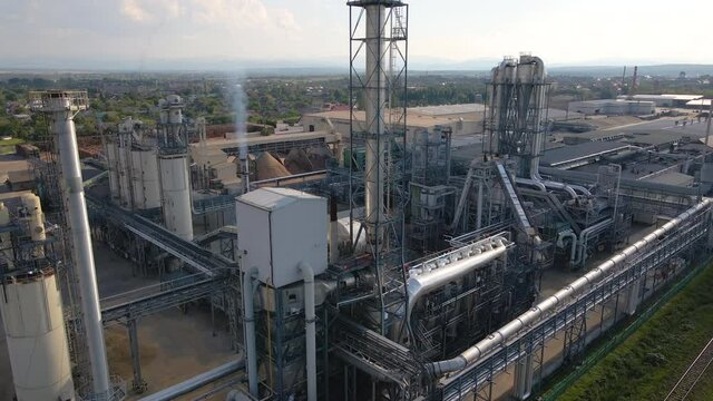Aerial view of oil and gas refining petrochemical factory with tall refinery plant manufacture structure.