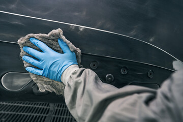Mechanic unoiling automobile surface with wiping cloth