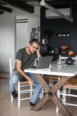 attractive nerdy man with glasses freelance working from home during the covid pandemic or flu