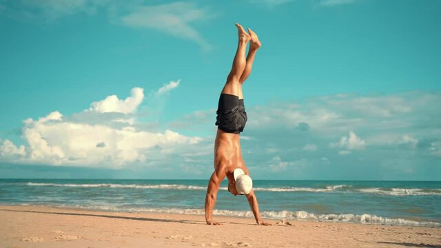 Fit young man practices sun salutation yoga on the beach. Young man enjoying meditation and yoga. fitness, sport, people and lifestyle concept - young man making yoga exercises.