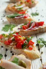 Delicious italian snacks bruschetta on white wooden background