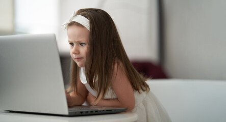 A cute little girl working with a laptop