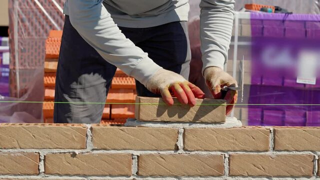 bricklayer lays a brick close-up