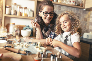 	
Mother and daughter playing in the kitchen and preparing dough to make cookies.Family concept.	
