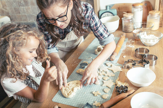 	
Mother and daughter playing in the kitchen and preparing dough to make cookies.Family concept.	
