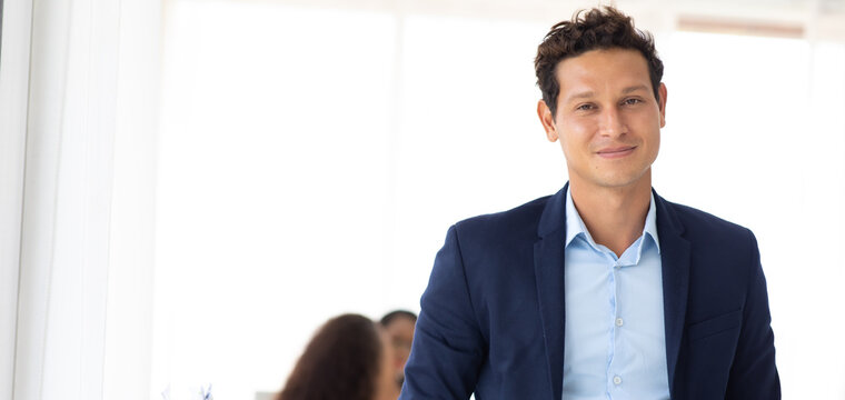 Business corporate leadership concept. Handsome cheerful hispanic creative business man at workspace office. Portrait