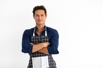 Portrait of smiling young hispanic man in apron looking at camera isolated on white background