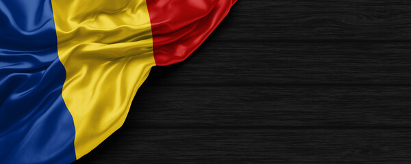 Close Up of Romania flag on the black wooden background 3D render