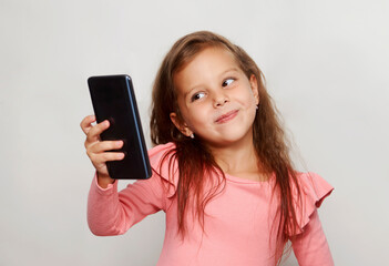 Naklejka premium Portrait of a little girl using cell phone against white background