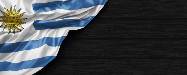 Close Up of Uruguay flag on the black wooden background 3D render