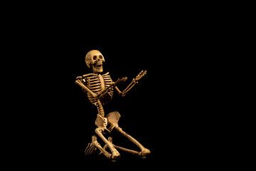 Human Skull skeleton praying on black background