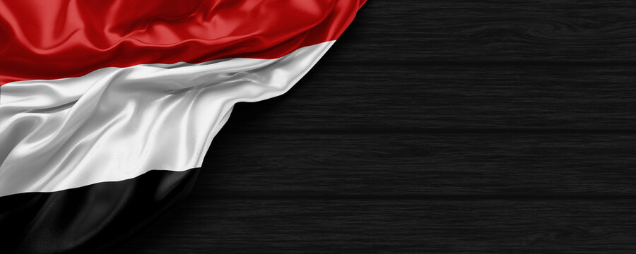 Close Up of Yaman flag on the black wooden background 3D render
