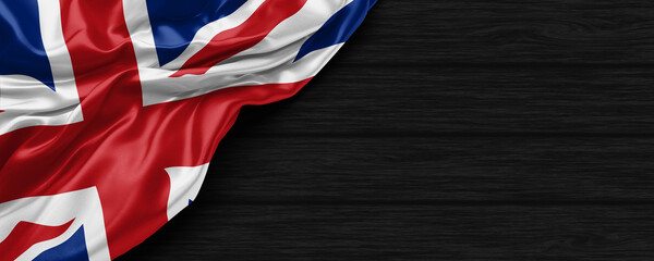 Close Up of United Kingdom flag on the black wooden background 3D render