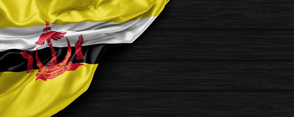 Close Up of Brunei Darussalam flag on the black wooden background 3D render