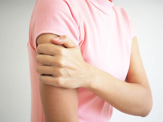 Woman having arm pain on a white background. closeup photo, blurred.