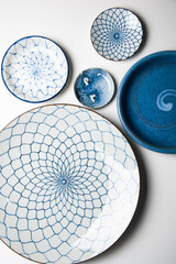 Top view of several porcelain plate with blue pattern on isolated on white