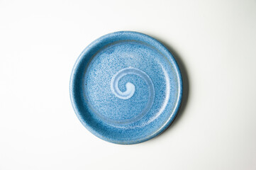 Top view of blue pottery plate with zen pattern isolated on white