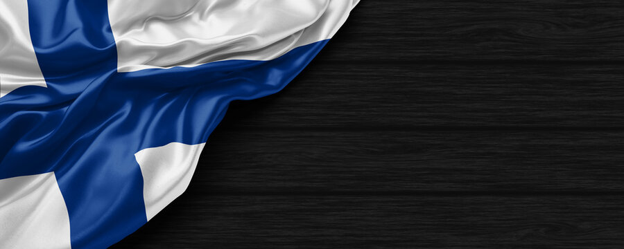 Close Up of Finland flag on the black wooden background 3D render