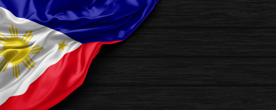 Close Up of Philippines flag on the black wooden background 3D render