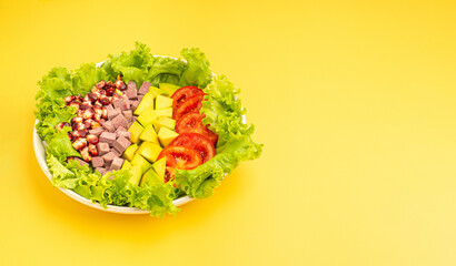 Top view of vegetable salad with fresh mixed purple corn, purple yams, avocado, and tomatoes on dish isolated on a yellow background. Space for text. Healthy foods and vegetable concept