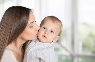Young beautiful mother lifting and playing with her baby.