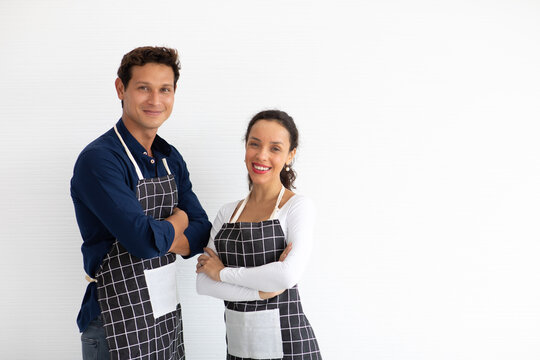 Hispanic Man And Woman Baristas Wearing Black Apron Arms Crossed On White Background.