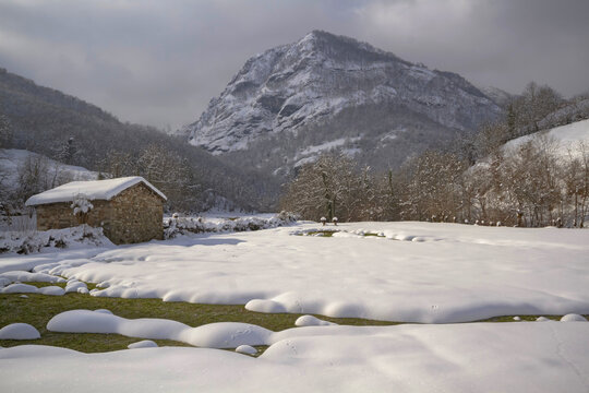 Small house in snowy mountain valley