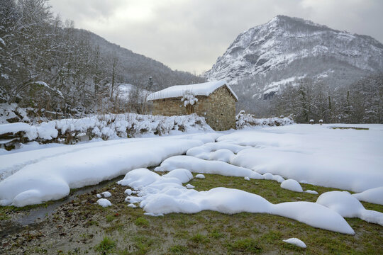 Small house in snowy mountain valley